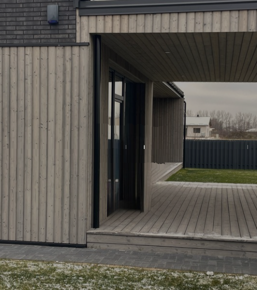 Charred decking beside a timber-clad house